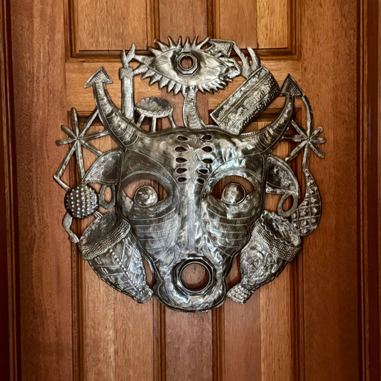 Handmade Haitian hammered metal wall art of a bull spirit hanging inside