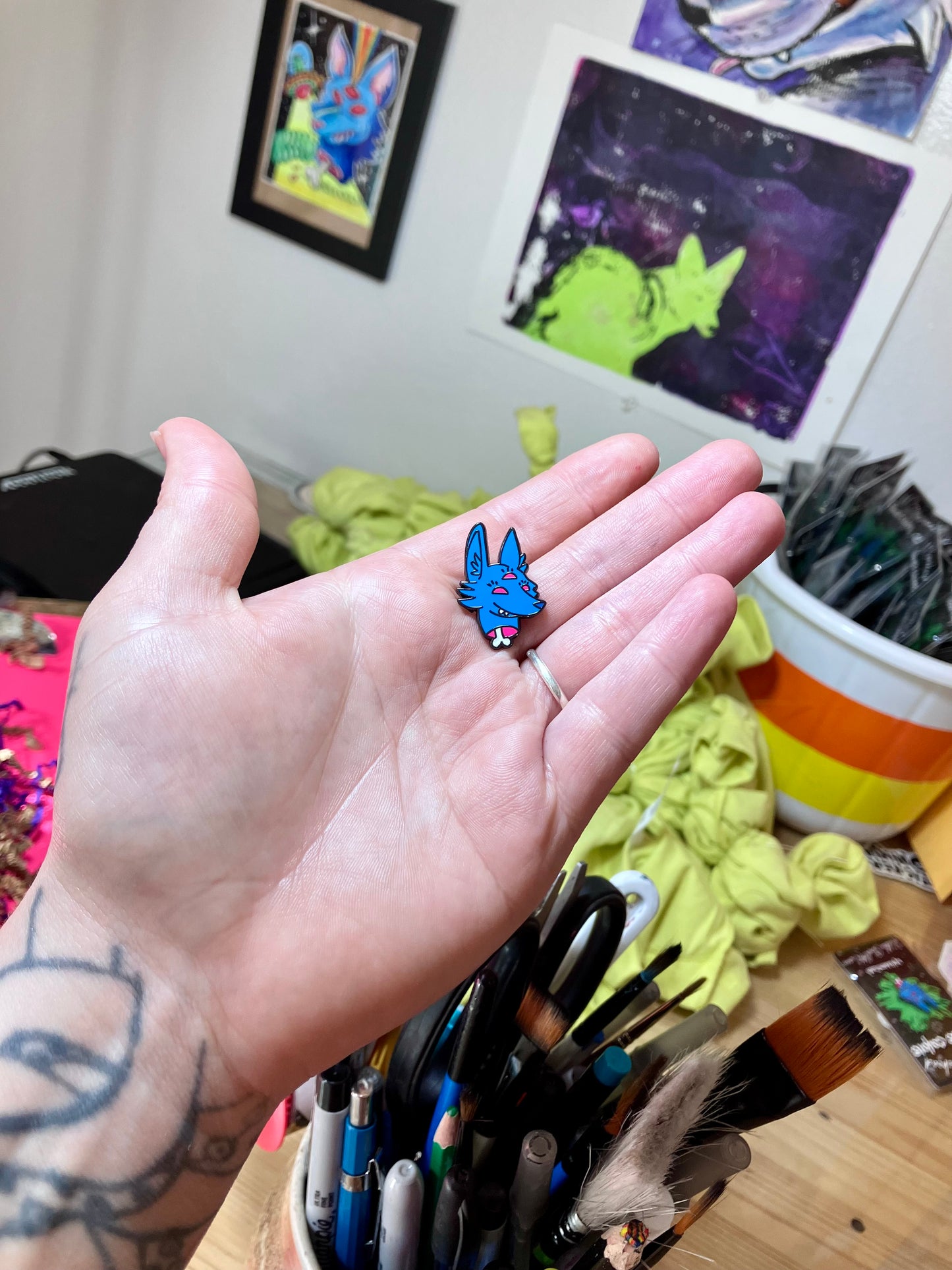 Handing holding the enamel pin with cartoon character Space Coyote by HiddenStash