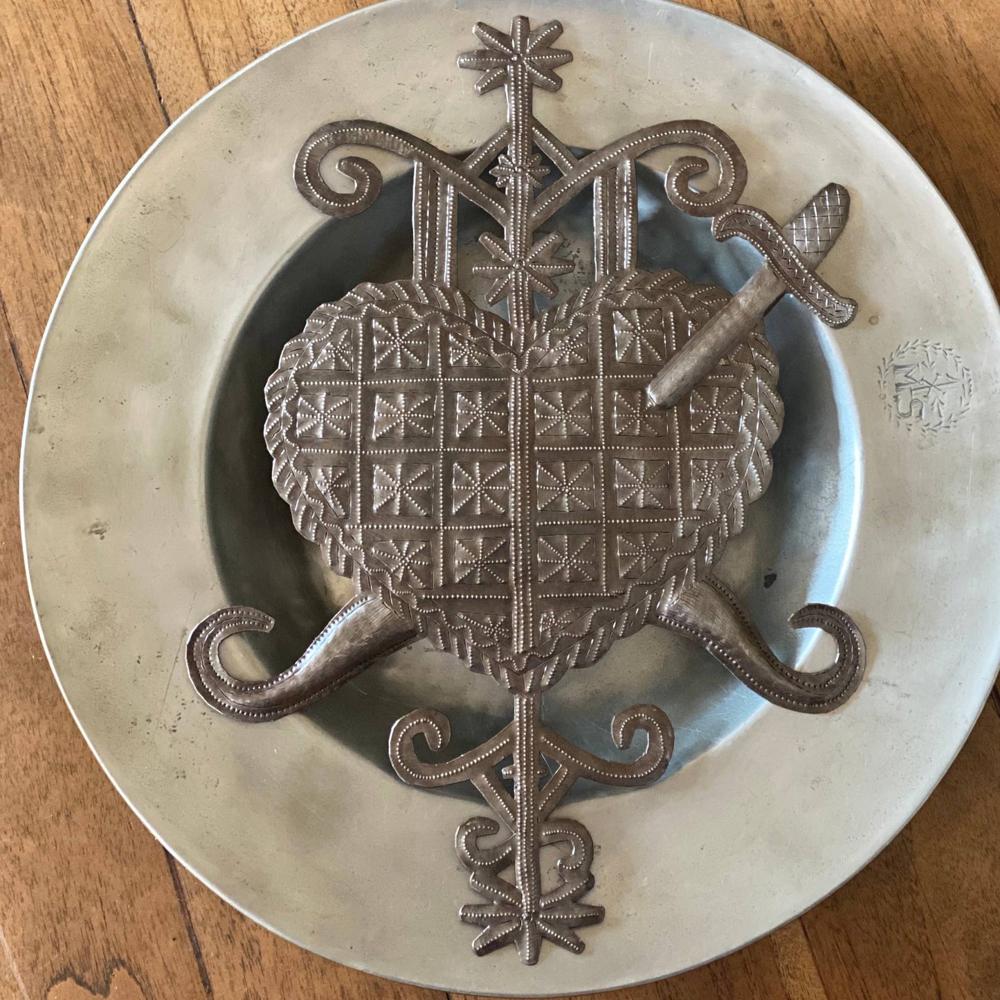 Handmade Haitian hammered metal wall art of a heart with a sword through it