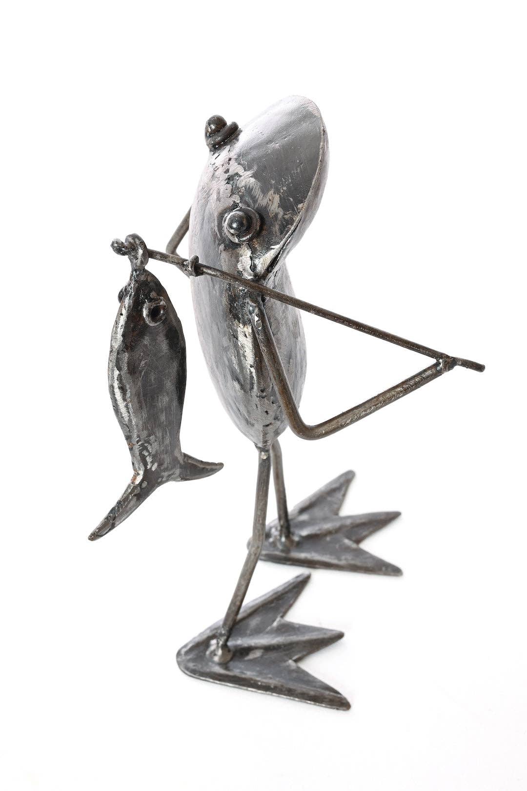 Metallic frog  holding a fishing pole with a fish on the end facing right
