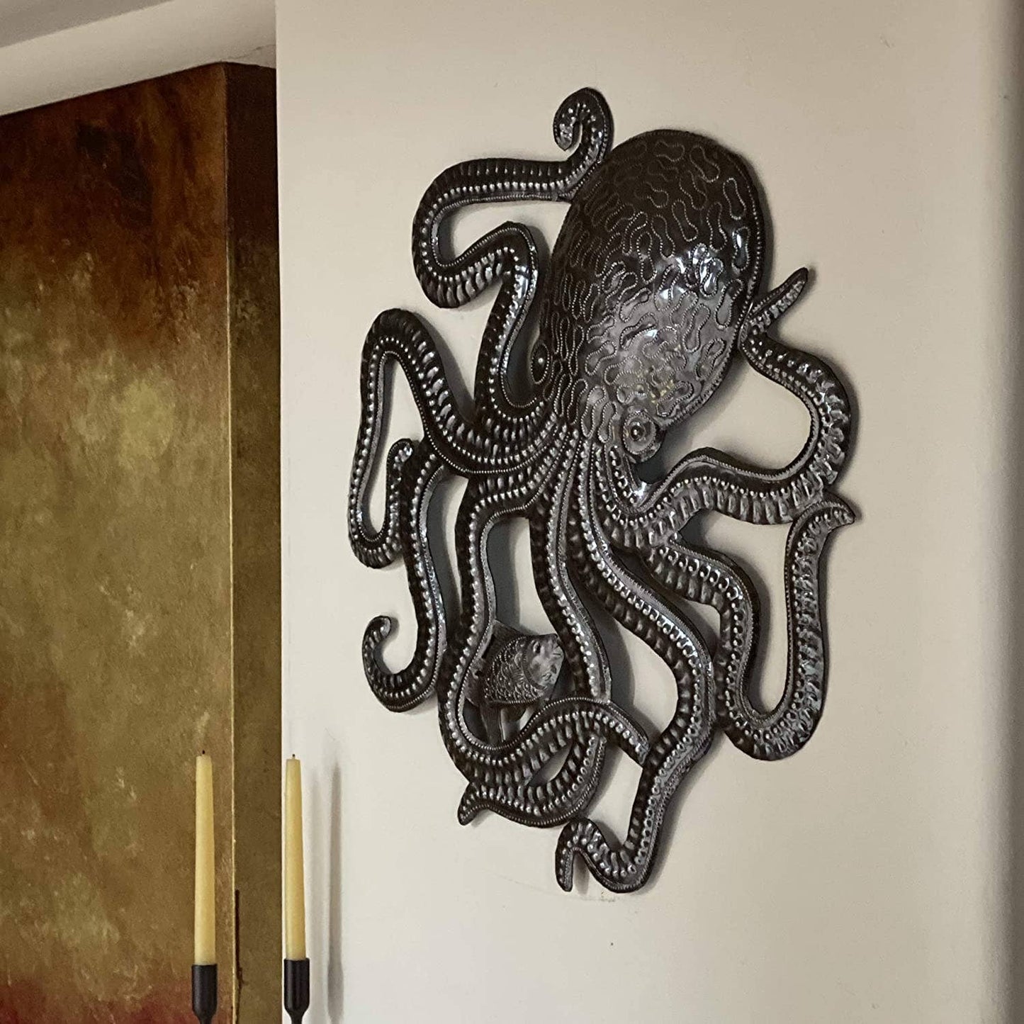 Handmade Haitian hammered metal wall art of an octopus and fish hanging inside