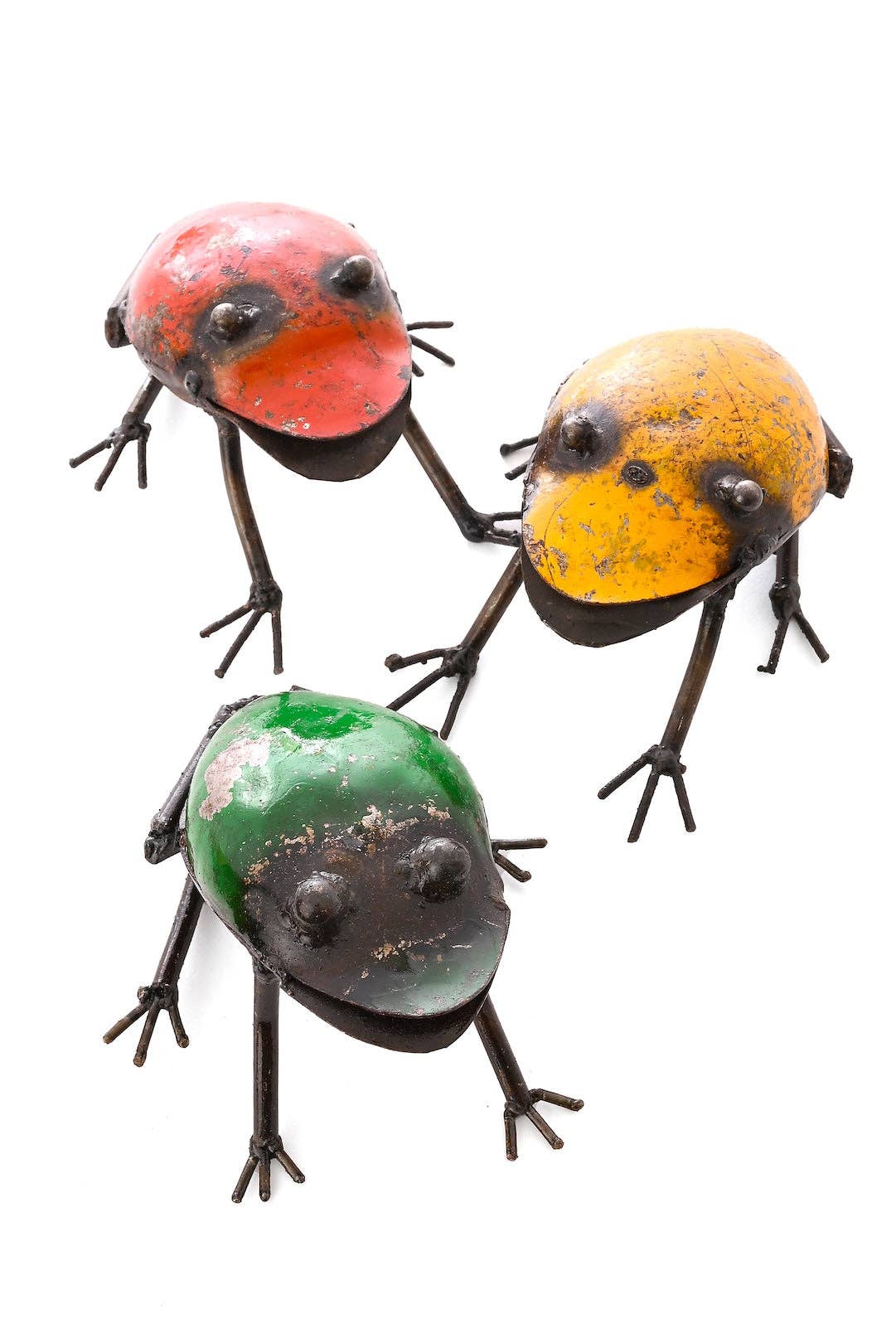 Three colorful metallic frogs, red, yellow, and green.