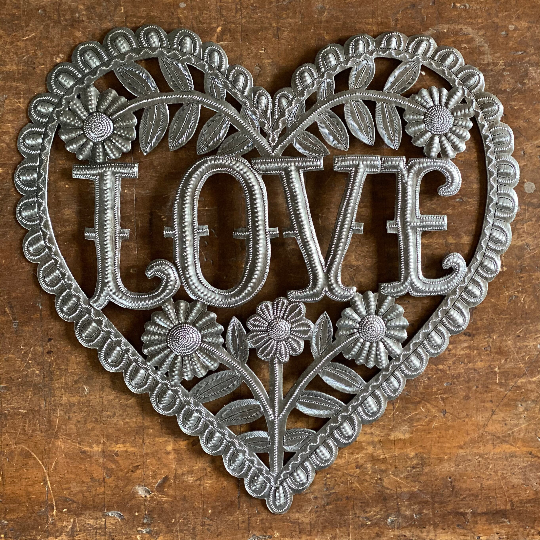 Handmade Haitian hammered metal wall art of a heart with the word Love surrounded by flowers