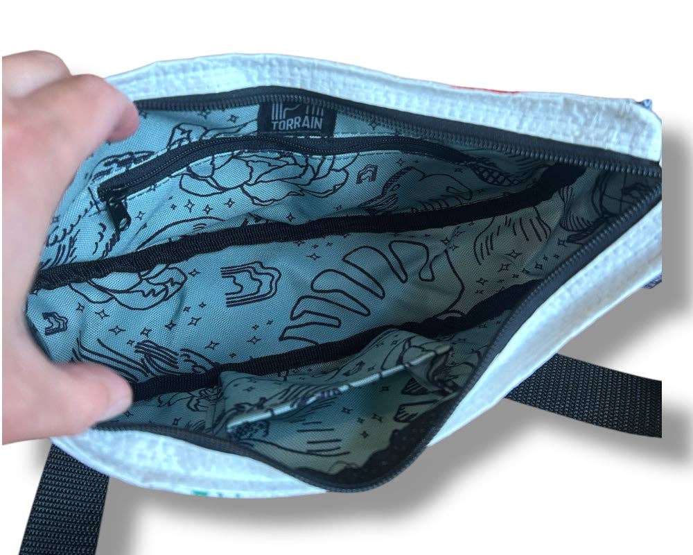 Interior of the cross body style bag. Exterior material is upcycled from feed and cement bags, Interior material is recycled from plastic bottles. Each design is unique.