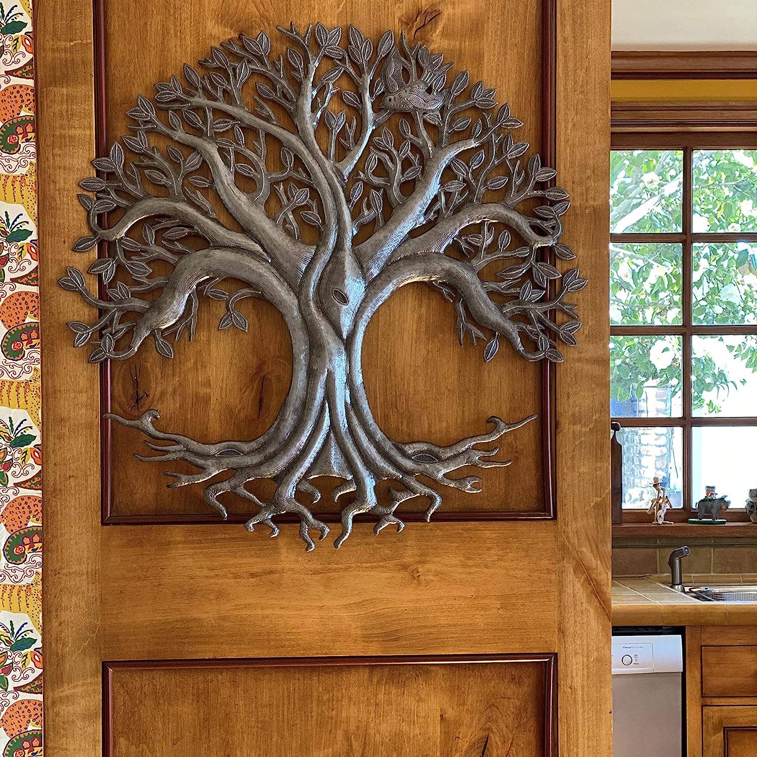 Handmade hammered metal wall art of a tree of life hanging inside