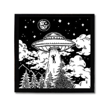 Patch of a UFO with a person being abducted, on black