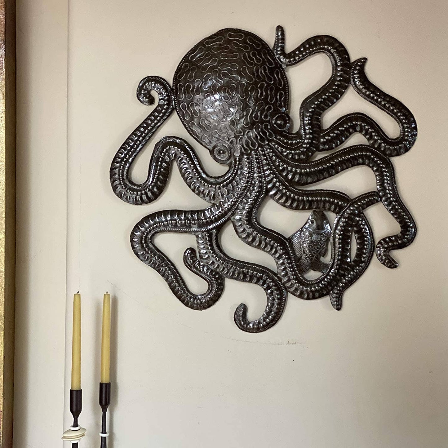 Handmade Haitian hammered metal wall art of an octopus and fish hanging inside