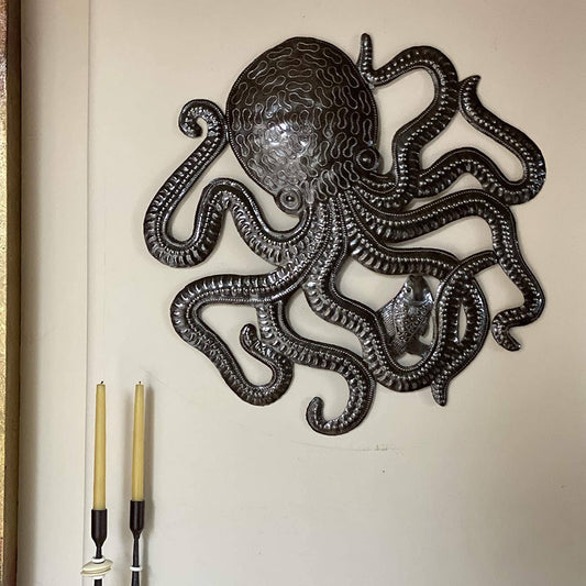 Handmade Haitian hammered metal wall art of an octopus and fish hanging inside