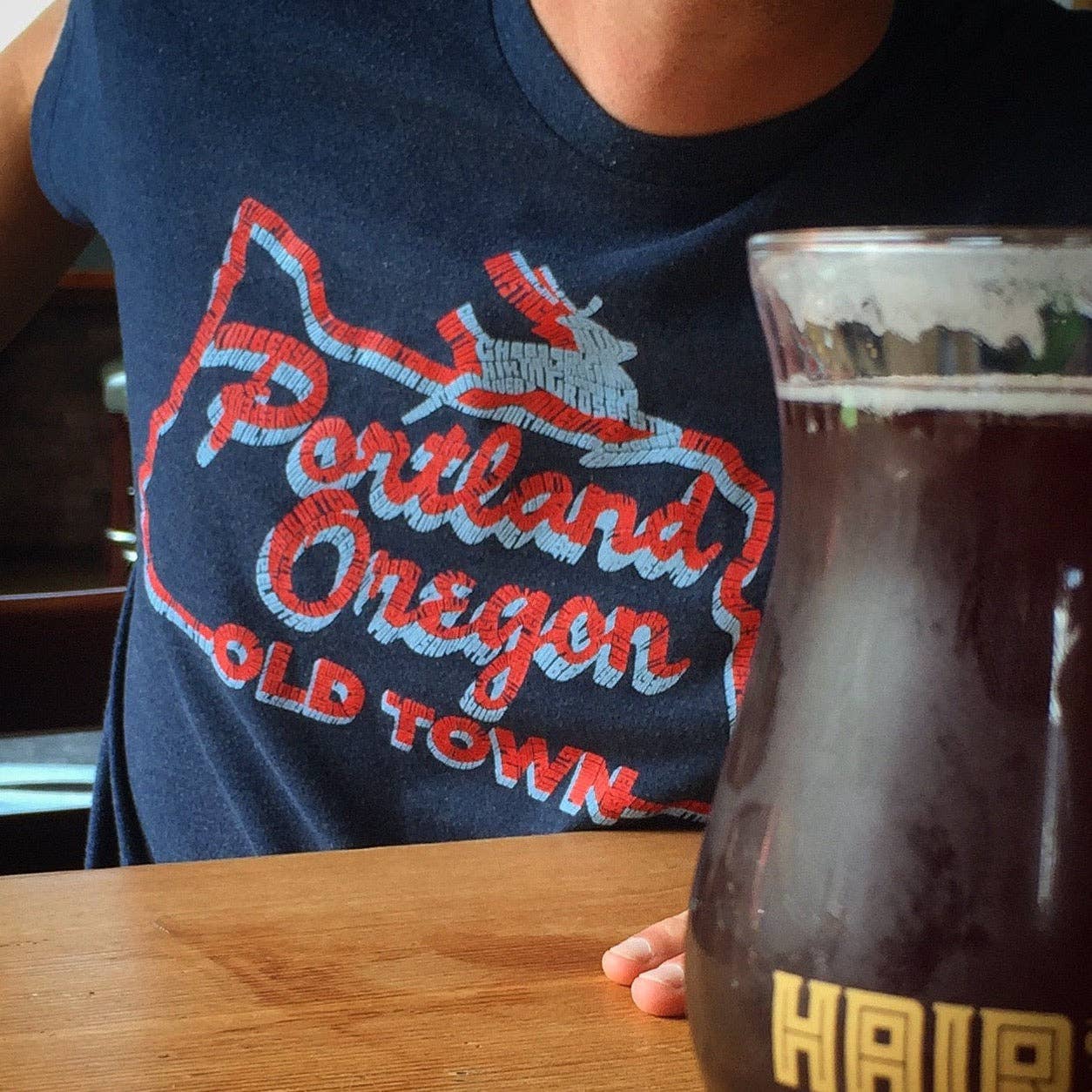 Person wearing a navy blue t-shirt with 'Portland Oregon Old Town' design