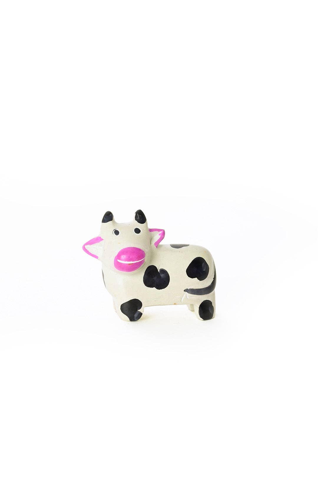 Closeup of a handcrafted soapstone cow with pink snouts and ears. 