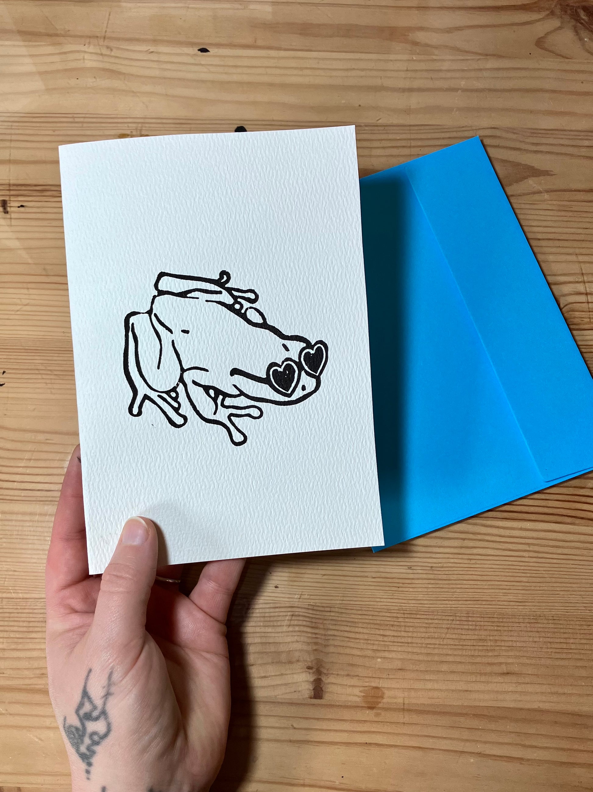 Greeting card designed with a frog wearing heart glasses