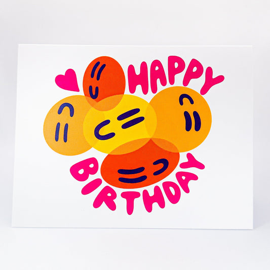 Colorful 'Happy Birthday' card with smiley face designs on a white background