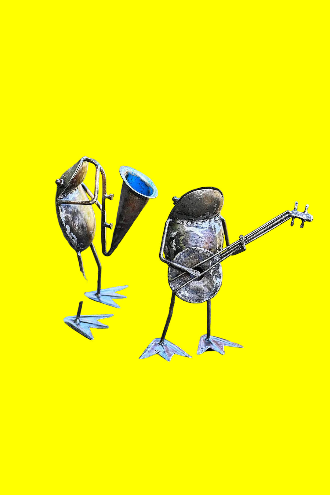 Handcrafted metallic sculpture of a frog playing a horn and another playing a banjo by the river.