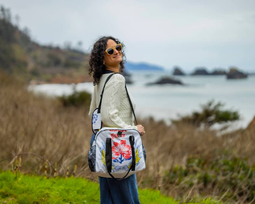 Person wearing the bowler style duffle bag. Exterior material is upcycled from feed and cement bags, Interior material is recycled from plastic bottles. Each design is unique.