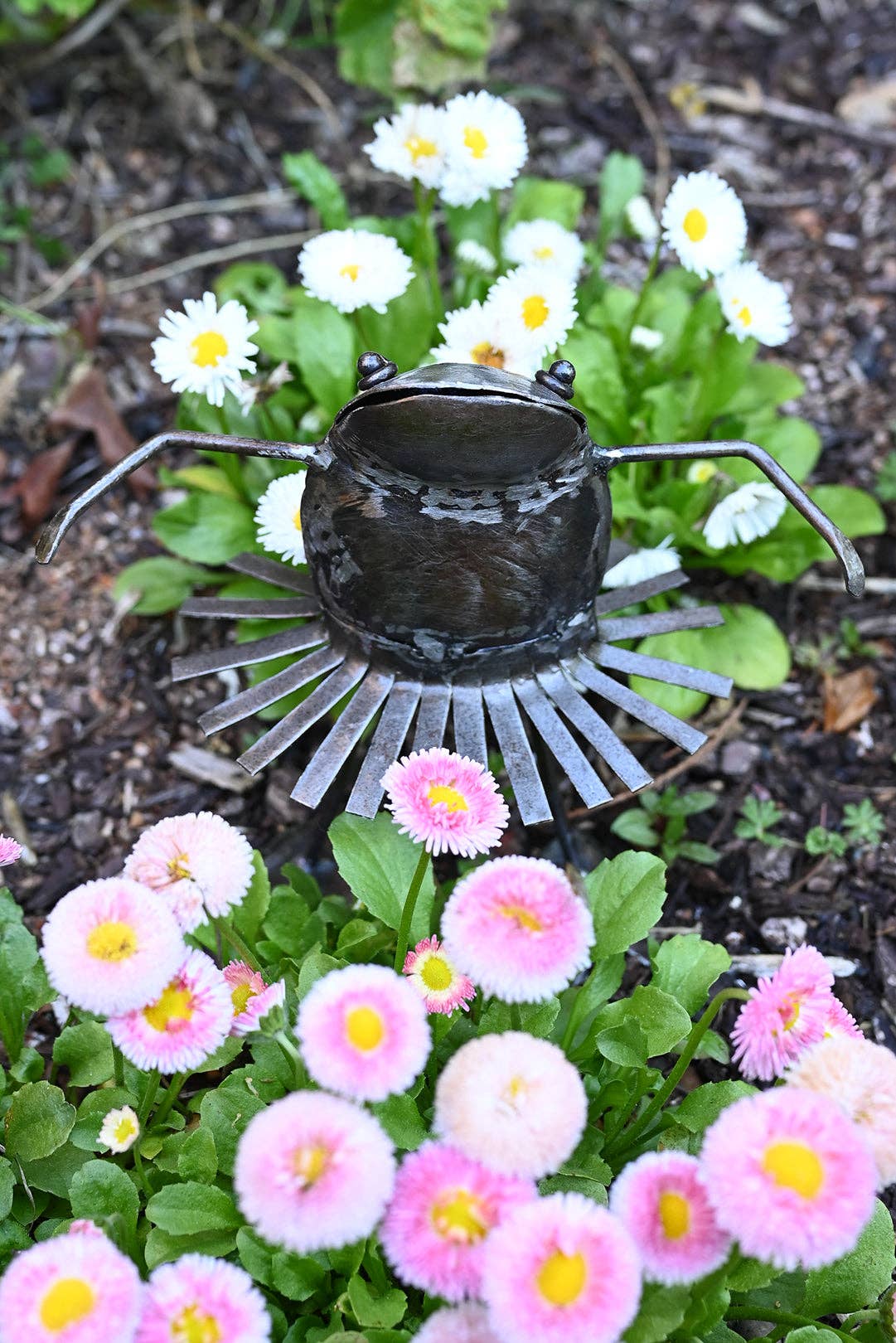 Metallic dancing frog with a swirling skirt among the flowers.