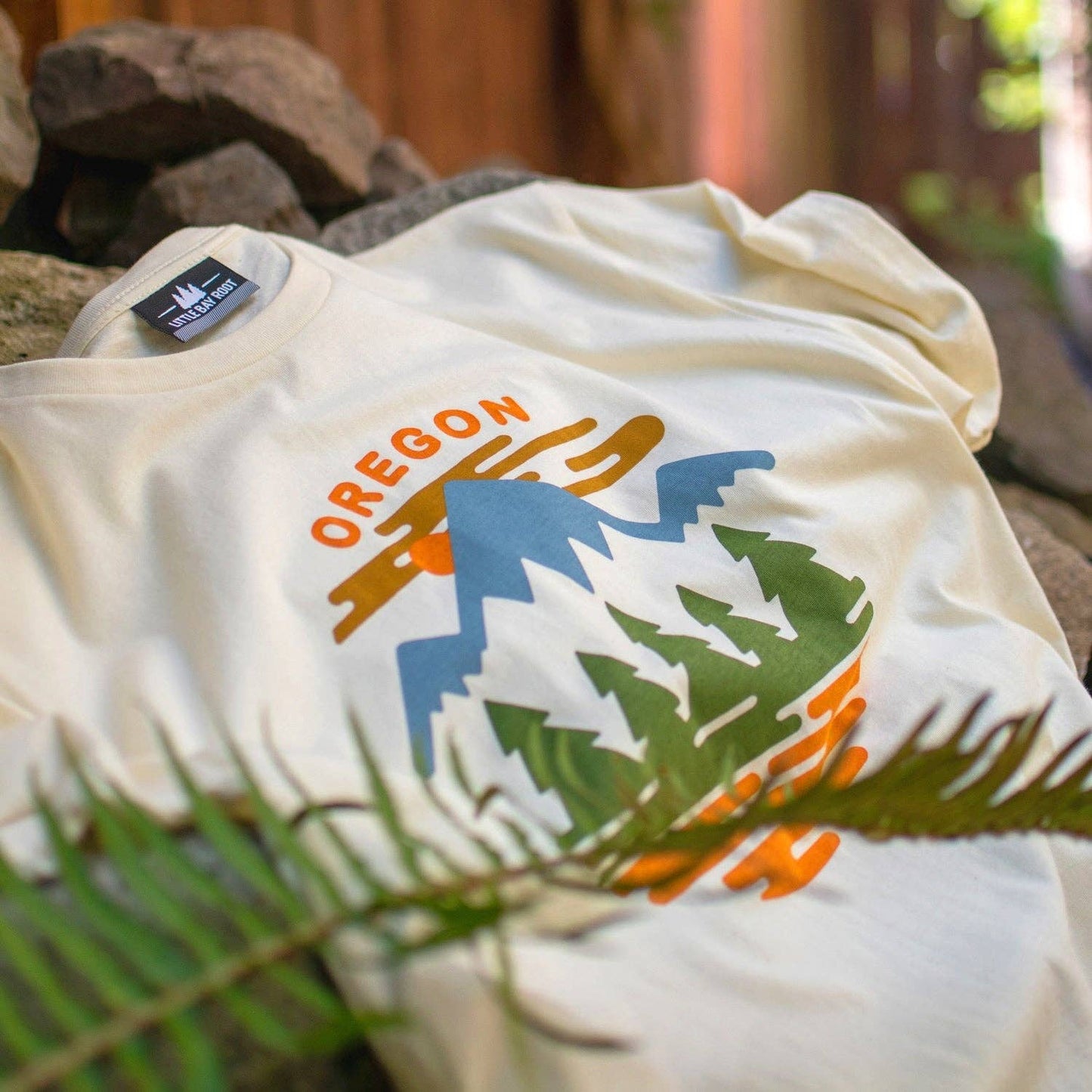 White t-shirt with 'Oregon' and nature graphic on a natural background
