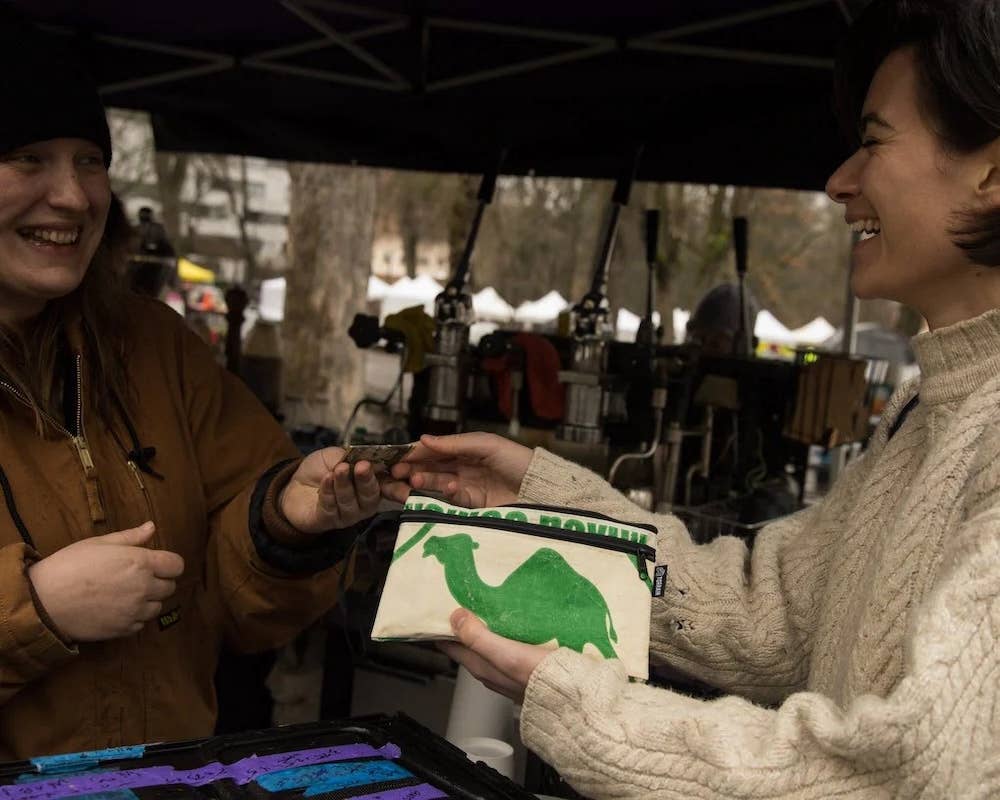 A pouch being used as a large wallet. Exterior material is upcycled from feed and cement bags, Interior material is recycled from plastic bottles. Each design is unique.