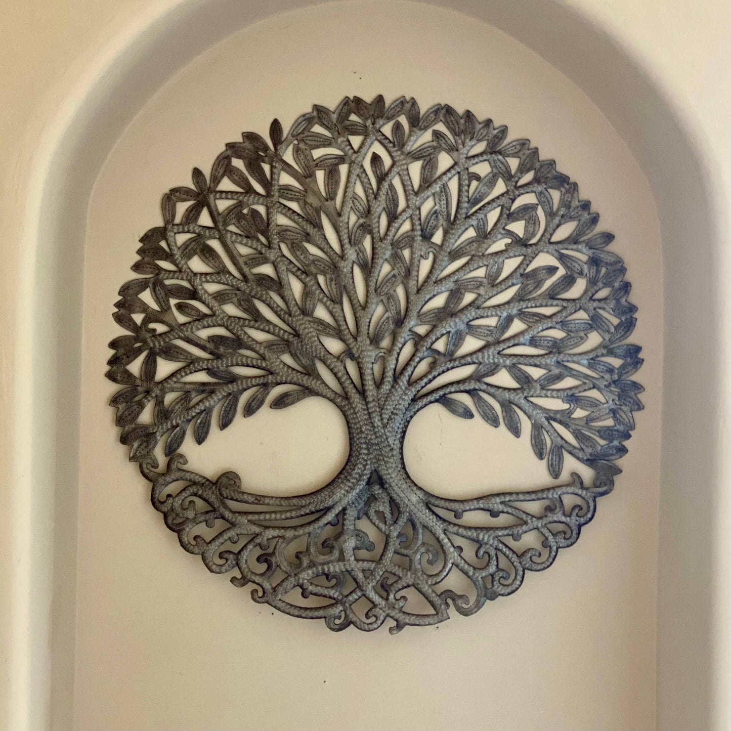 Handmade hammered metal wall art of a tree with intricate designs