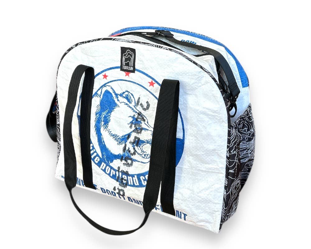 Bowler style duffle bag. Exterior material is upcycled from feed and cement bags, Interior material is recycled from plastic bottles. Each design is unique.